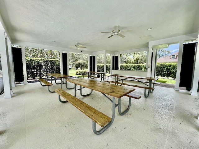 surrounding community with a ceiling fan and a patio