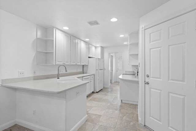 kitchen featuring a peninsula, a sink, white cabinetry, light countertops, and open shelves