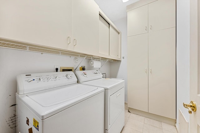 laundry area featuring cabinets, light tile patterned floors, and separate washer and dryer