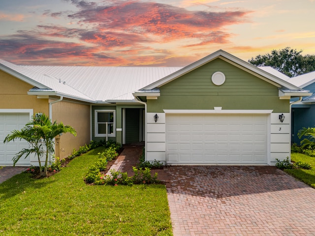 ranch-style home with a garage and a yard