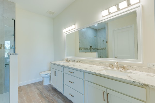 bathroom with vanity, hardwood / wood-style flooring, toilet, and a shower with shower door