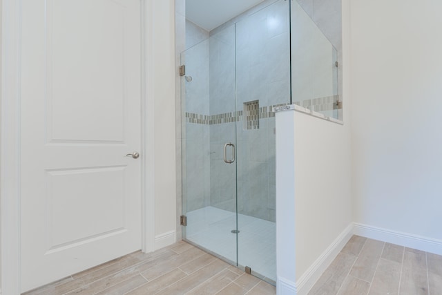 bathroom with a shower with door