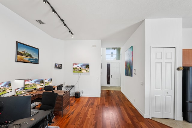 office featuring a textured ceiling, dark wood-type flooring, and track lighting