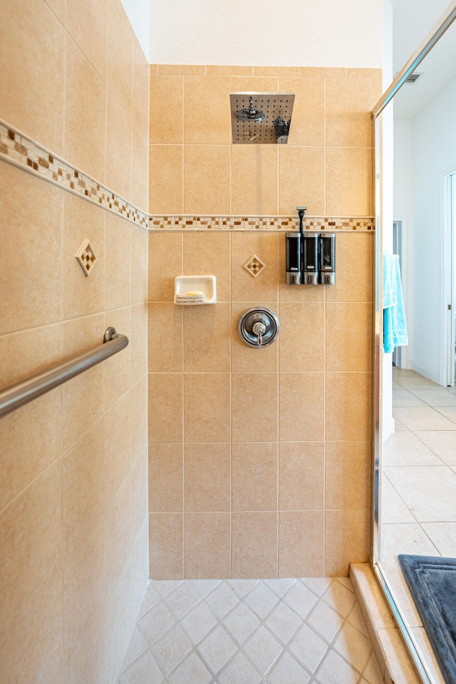 bathroom featuring tile patterned flooring and tiled shower