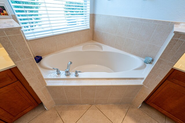 bathroom featuring tile patterned floors, tiled bath, and vanity