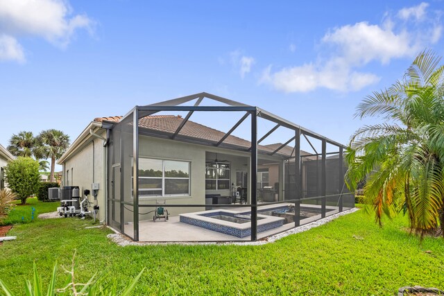 rear view of house with glass enclosure, a patio area, a yard, and central AC