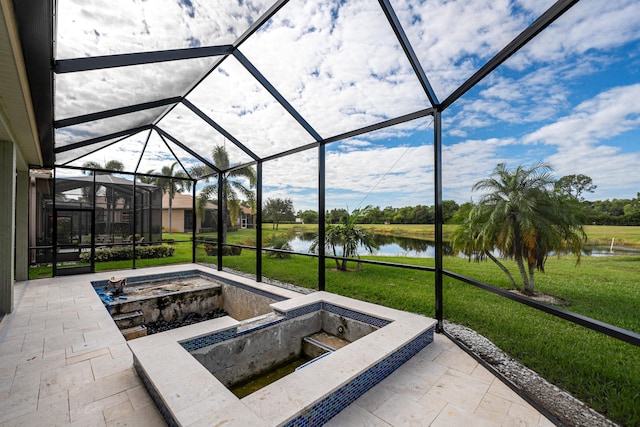 view of patio with a lanai and a water view