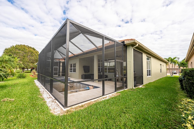 rear view of house featuring a yard, a patio area, and a lanai