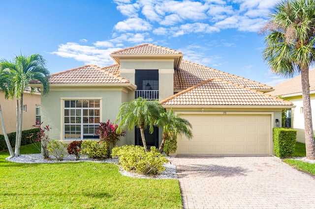 mediterranean / spanish home featuring a garage and a front lawn