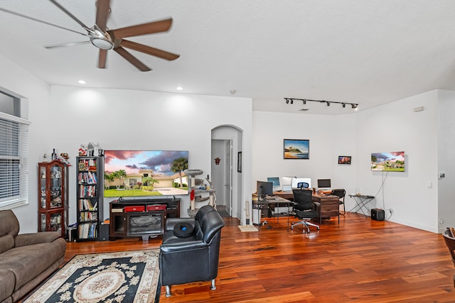 living room featuring ceiling fan, a textured ceiling, and hardwood / wood-style flooring