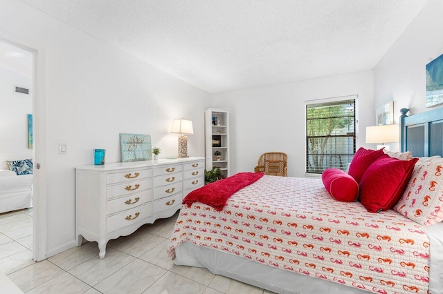 bedroom with light tile patterned floors and a textured ceiling