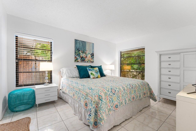 bedroom featuring light tile patterned floors and a textured ceiling