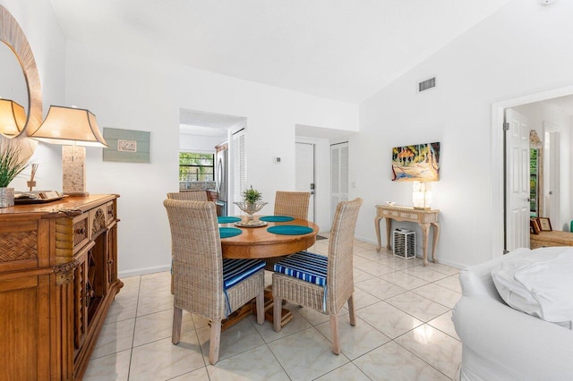 dining area featuring light tile patterned floors and vaulted ceiling