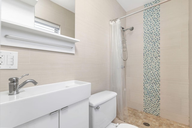 bathroom with a shower with shower curtain, vanity, toilet, and tile walls