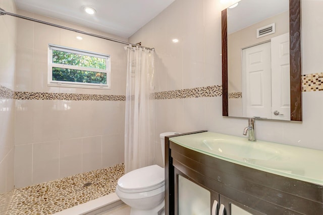 bathroom featuring curtained shower, vanity, tile walls, and toilet