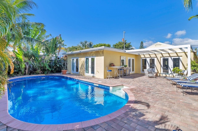 view of pool featuring a bar and a patio