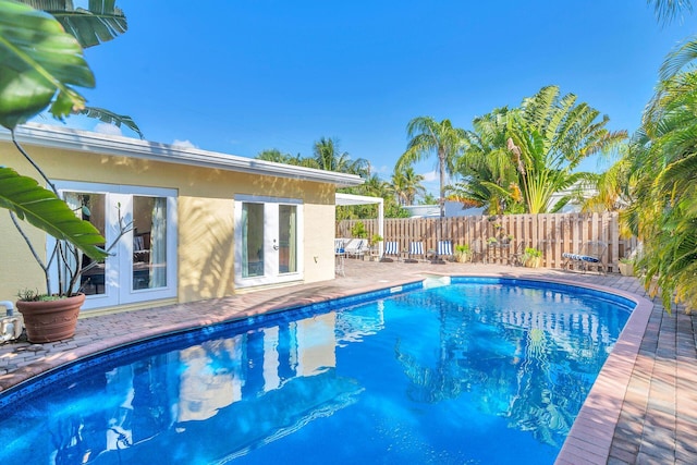 view of swimming pool featuring a patio area and french doors