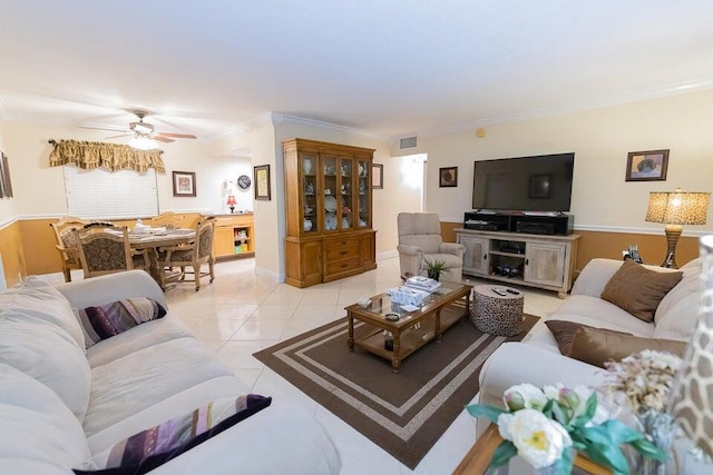 tiled living room with ornamental molding and ceiling fan