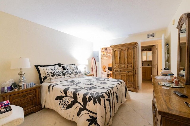 bedroom with light tile patterned flooring and ensuite bathroom