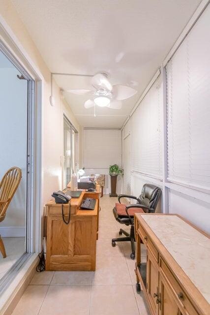 tiled office space featuring ceiling fan