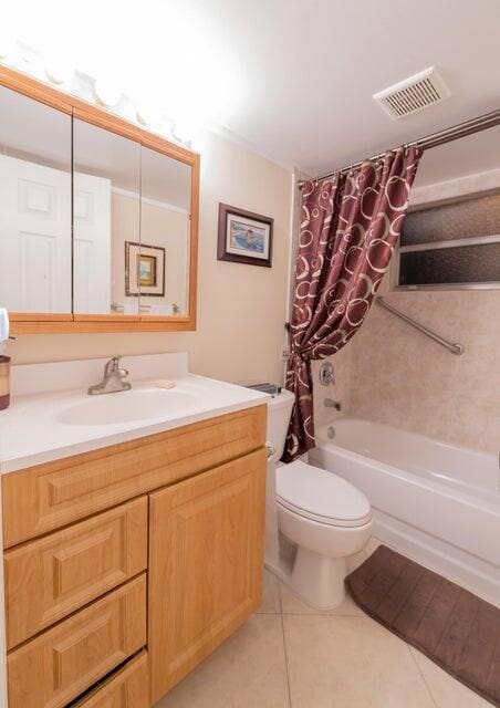 full bathroom with toilet, tile patterned floors, vanity, and shower / bath combo with shower curtain