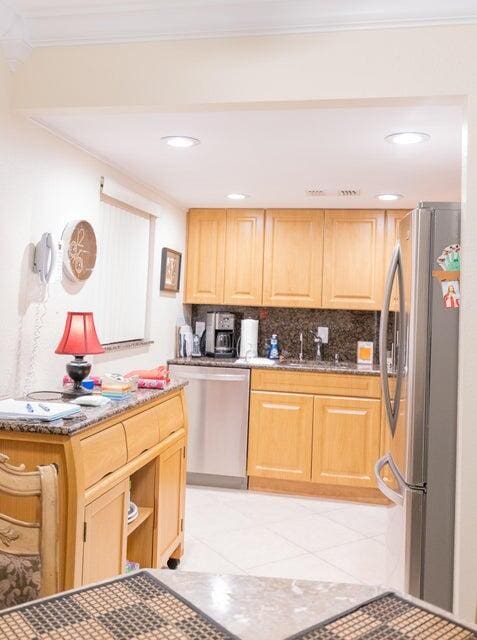 kitchen featuring decorative backsplash, sink, crown molding, appliances with stainless steel finishes, and dark stone countertops