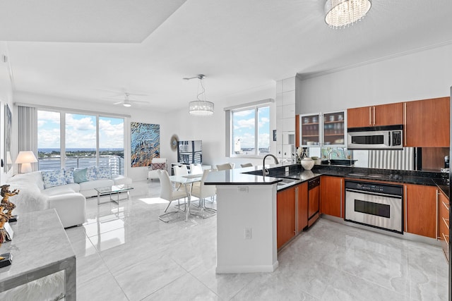 kitchen featuring stainless steel appliances, a healthy amount of sunlight, sink, and decorative light fixtures