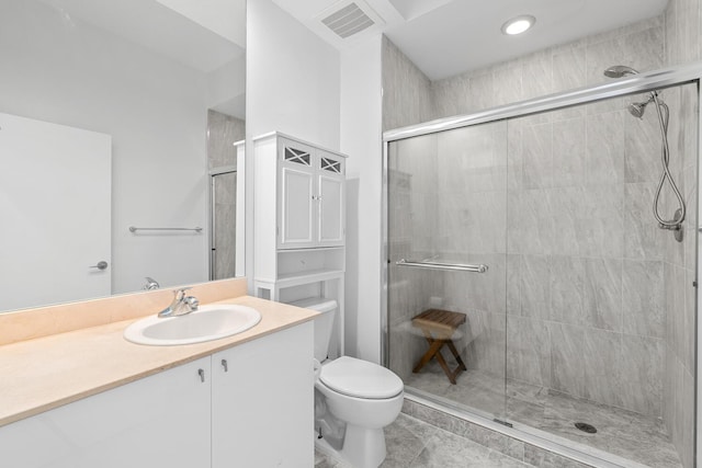 bathroom featuring vanity, walk in shower, and toilet