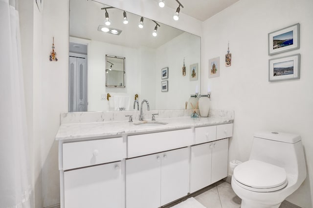 bathroom with toilet, vanity, and tile patterned floors