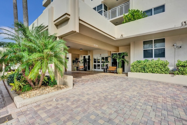 doorway to property featuring french doors, a balcony, and a patio area