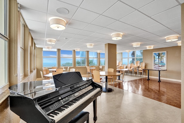 misc room with a water view, a healthy amount of sunlight, light parquet floors, and a paneled ceiling