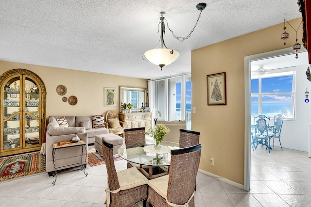 tiled dining space featuring a wealth of natural light and a textured ceiling