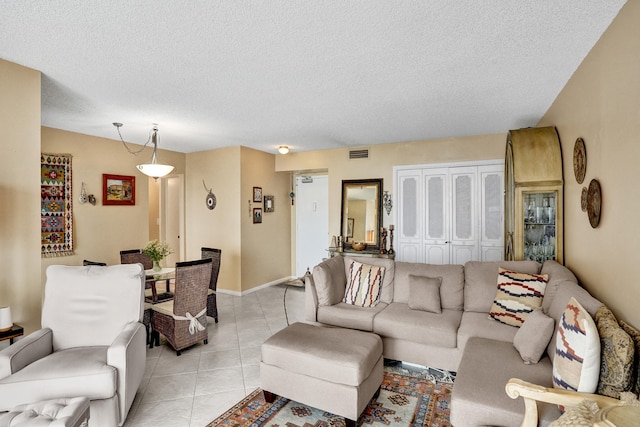 living room featuring a textured ceiling and light tile patterned floors