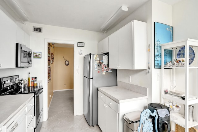 kitchen with white cabinetry, light tile patterned floors, and stainless steel appliances