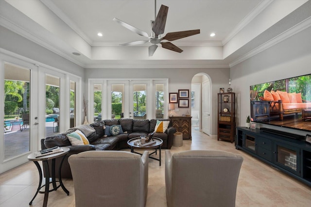 living area with ornamental molding, a tray ceiling, french doors, and light tile patterned floors