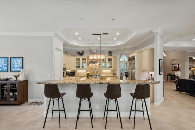 kitchen with a spacious island, a breakfast bar area, and cream cabinets