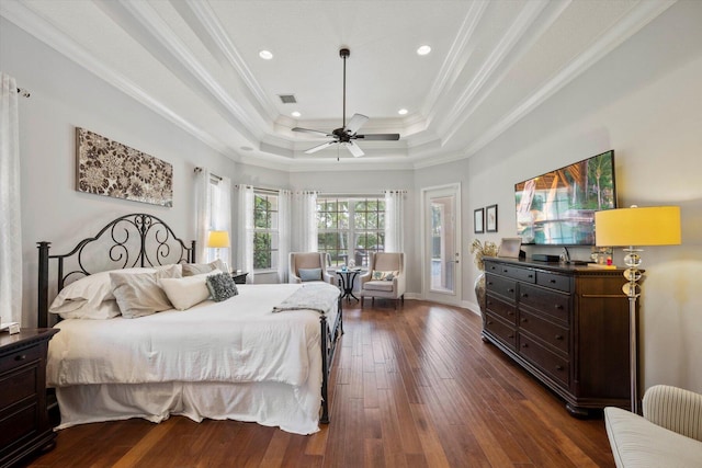 bedroom with ceiling fan, a raised ceiling, dark hardwood / wood-style flooring, and ornamental molding