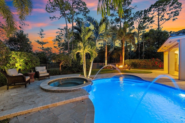 view of swimming pool with a fenced backyard, a pool with connected hot tub, and a patio