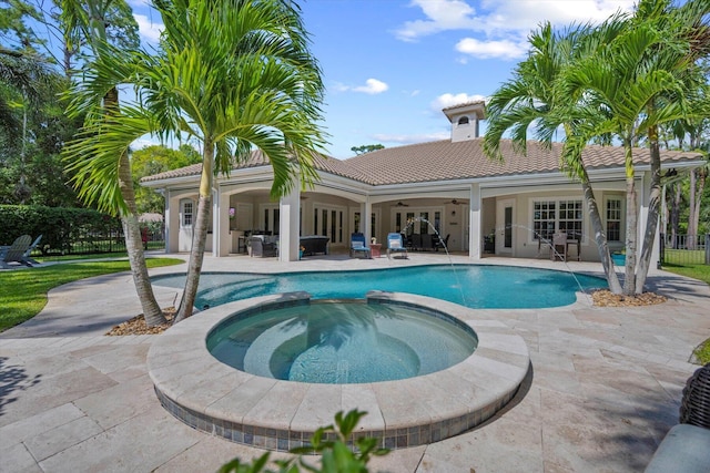 view of pool featuring fence, a pool with connected hot tub, a ceiling fan, french doors, and a patio area