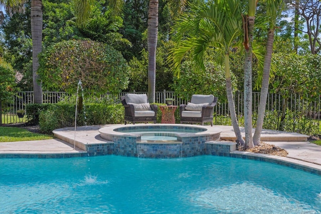 view of swimming pool featuring a pool with connected hot tub and fence