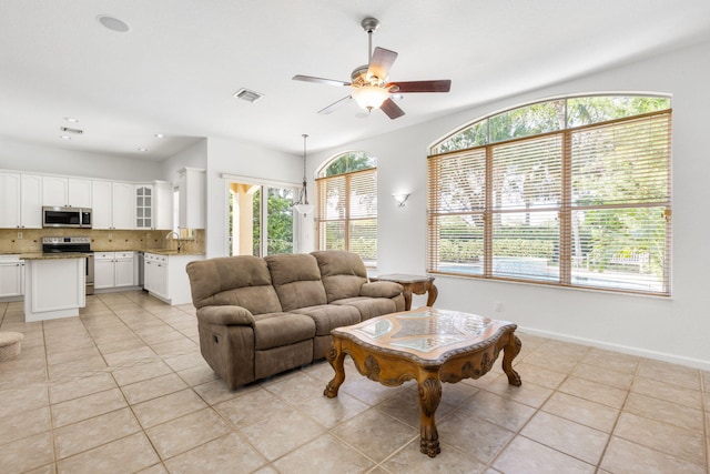 tiled living room with a healthy amount of sunlight, ceiling fan, and sink