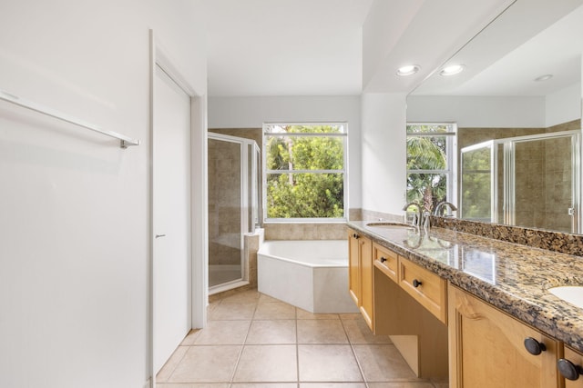 bathroom featuring tile patterned flooring, vanity, and shower with separate bathtub