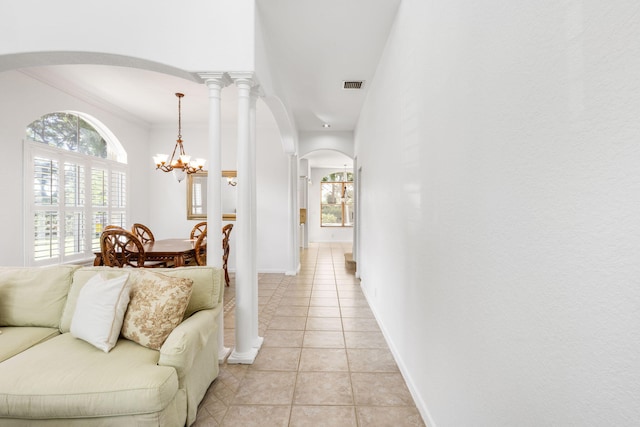 hall with a notable chandelier and light tile patterned floors