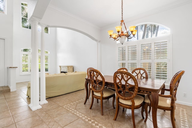 tiled dining space featuring ornate columns, a notable chandelier, and ornamental molding