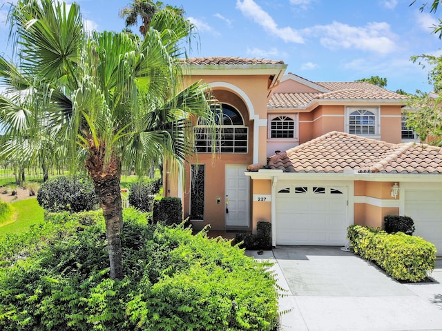 227 Legendary Cir, Palm Beach Gardens, FL 33418 - mediterranean / spanish house with a garage, a tiled roof, stucco siding, and concrete driveway