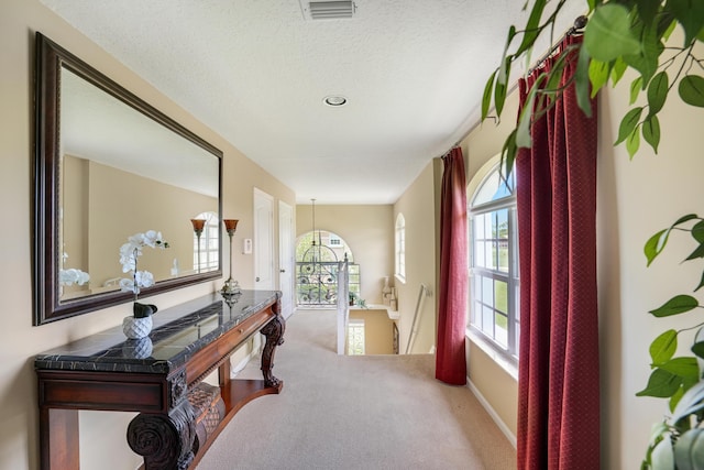 227 Legendary Cir, Palm Beach Gardens, FL 33418 - hall featuring an upstairs landing, carpet, and a textured ceiling