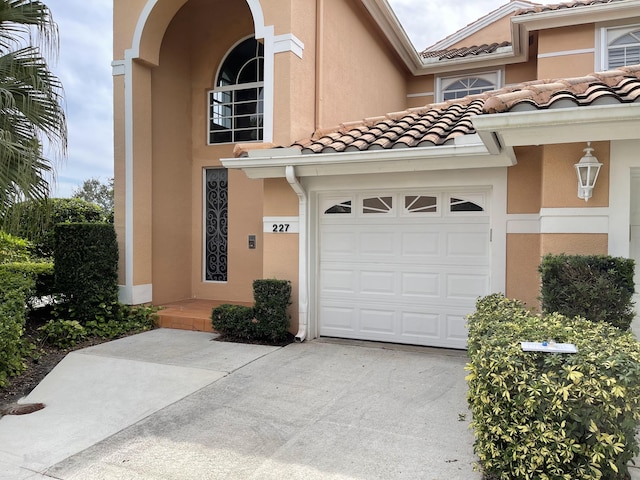 227 Legendary Cir, Palm Beach Gardens, FL 33418 - view of front of house featuring stucco siding, concrete driveway, a tile roof, and a garage