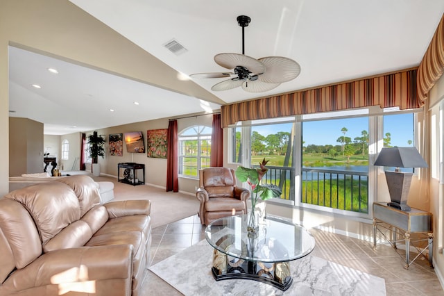 tiled living room featuring a water view, lofted ceiling, and ceiling fan