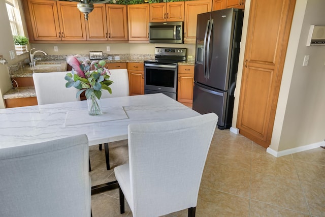 227 Legendary Cir, Palm Beach Gardens, FL 33418 - kitchen with appliances with stainless steel finishes, light stone counters, light tile patterned flooring, and a sink