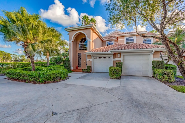 227 Legendary Cir, Palm Beach Gardens, FL 33418 - mediterranean / spanish house featuring stucco siding, driveway, a garage, and a tiled roof